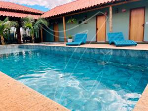 zwei blaue Stühle neben einem Swimmingpool in der Unterkunft Recanto dos Sonhos - Rio Quente - Goiás in Rio Quente