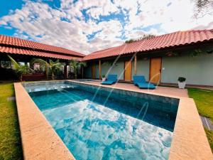 ein Swimmingpool vor einem Haus in der Unterkunft Recanto dos Sonhos - Rio Quente - Goiás in Rio Quente