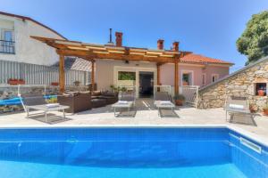 a patio with a swimming pool and a house at Villa Milla in Novi Vinodolski
