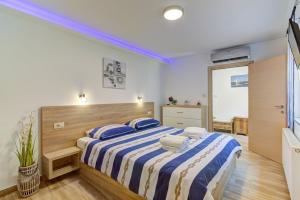 a bedroom with a large bed with blue and white sheets at Villa Milla in Novi Vinodolski +43 photos