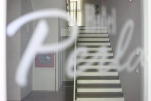 a hallway with stairs and a stair railing in a building at Hotel Perla in Castiglione della Pescaia