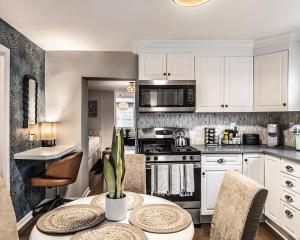 a kitchen with white cabinets and a table at Red Robin Rentals - Wicker Park in Chicago