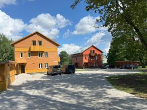 Dos casas y dos coches estacionados en un estacionamiento. en Cozy Tartu Apple Garden with Terrace, en Tartu