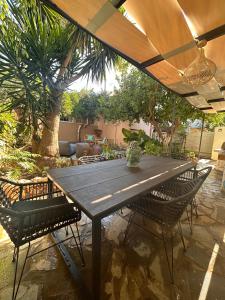 a wooden table and chairs under an umbrella at Joyful Secret Garden Residence Downtown by 8essentially in Chania