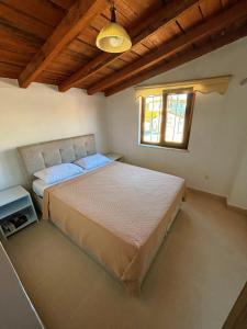 a bedroom with a bed and a window at Huzur Pansiyon in Çanakkale