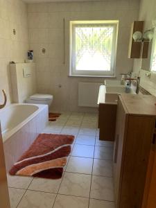 a bathroom with a tub and a toilet and a sink at Schöne Ferienwohnung in der Fränkischen Schweiz in Greifenstein