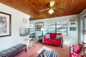 een woonkamer met een rode bank en een plafondventilator bij Lake June Resort #10 in Lake Placid