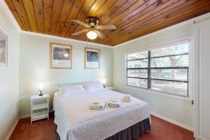 een slaapkamer met een bed, een plafondventilator en een raam bij Lake June Resort #10 in Lake Placid