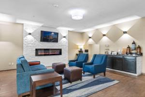 a living room with blue chairs and a fireplace at Comfort Inn Hobart-Merrillville I-65 in Merrillville