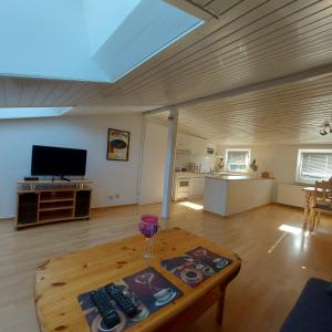 a living room with a table and a tv at Flensburg Ferienwohnung Apartment nähe Zentrum und Uni in Flensburg