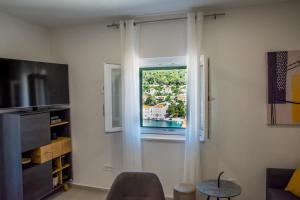 a living room with a window and a table at Apartment Paradise Island in Pučišća