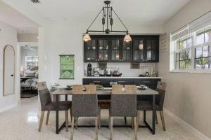 a kitchen and dining room with a table and chairs at Welcome To Sanctuary & Flair - Casa de Photograph in North Fort Myers
