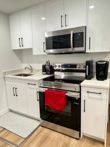 a kitchen with a stove and a microwave at Stylish & Modern 2 Bedroom Suite in Regina +29 photos