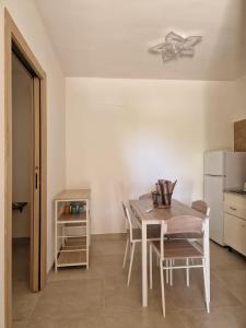 a kitchen with a table and chairs and a refrigerator at Villa GRAZIA in Leporano Marina