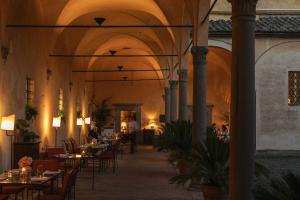 restauracja ze stołami i krzesłami w budynku w obiekcie Hotel Certosa Di Maggiano w Sienie