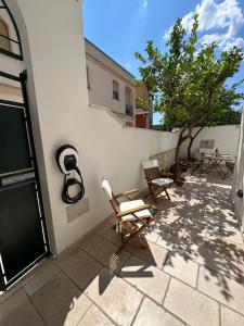 a patio with two chairs next to a building at Casetta di Tiggiano - Boutique house in Tiggiano