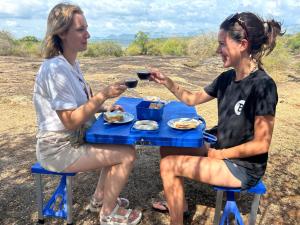 two women sitting at a picnic table drinking wine at Thought Blooming in Udawalawe