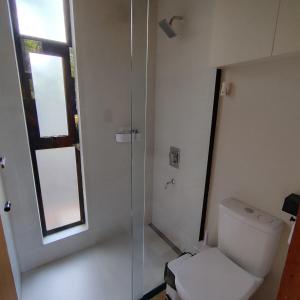 a bathroom with a toilet and a glass shower at Tokai Surubi'i in Colonia Mariano Roque Alonso +2 photos