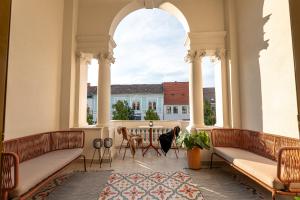 een kamer met 2 banken en een tafel met een raam bij Catalog Boutique Rooms Cluj-Napoca in Cluj-Napoca