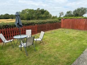 a table and chairs with an umbrella in a yard at Chapel Cottage in Bramfield +4 photos