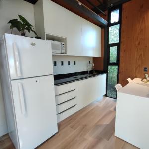 a kitchen with white appliances and wooden walls at Tokai Surubi'i in Colonia Mariano Roque Alonso