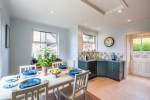 a dining room with a table and chairs and a kitchen at Dun Brae Cottage in Dornoch