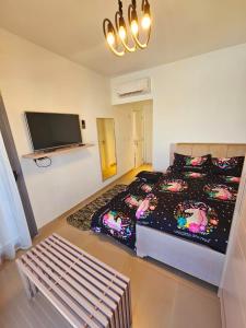 a bedroom with a bed and a tv and a bench at Townhouse Villa Marassi North Coast in El Alamein