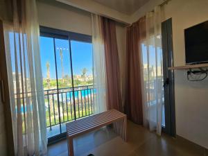 a room with a window with a view of a pool at Townhouse Villa Marassi North Coast in El Alamein