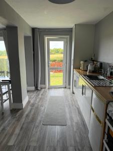 a kitchen with a door open to a patio at Chapel Cottage in Bramfield