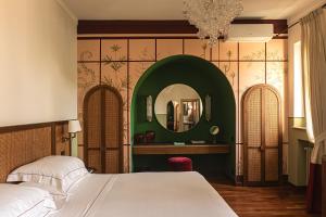 a bedroom with a bed and a mirror at Hotel Certosa Di Maggiano in Siena