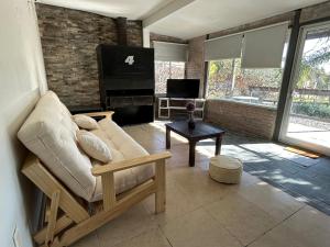 梅塞德斯Casa un dormitorio Los Arrayanes的带沙发和钢琴的客厅