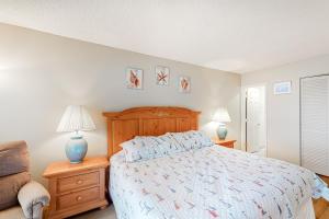 a bedroom with a bed and two lamps and a chair at Sea Colony - 806 Dover House Rd. in Bethany Beach +30 photos
