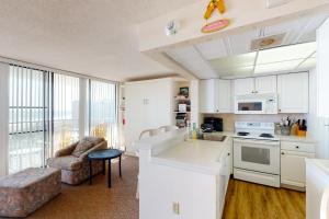 a kitchen with white cabinets and a living room at Sea Colony - 709 Dover House Rd. in Bethany Beach