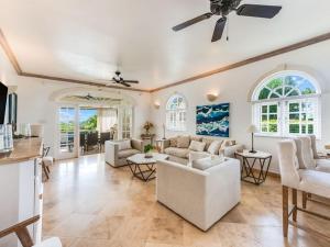 a living room with white furniture and a ceiling fan at Tamarind Villa - Sugar Hill in Saint James