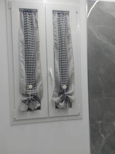 a white cabinet with two doors with ties at Sweet home in Priolo Gargallo
