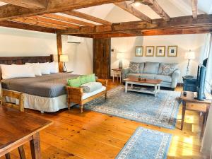 a bedroom with a bed and a couch and a table at The Black Walnut Inn in Amherst