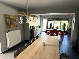 a kitchen and dining room with a wooden table and chairs at Chambre de la Wamme 2 in Marche-en-Famenne +1 photo