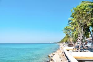 a beach with palm trees and the ocean at The Sunset Bangsaen Hotel in Ban Rong Khoei +16 photos