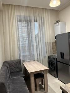 a living room with a couch and a table and a refrigerator at Apartment in the city center on Bagramyan avenue 23 in Yerevan