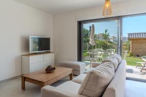 un soggiorno con un divano e una TV di Superbe maison neuve proche centre-ville et plage pour 4 personnes a Neufchâtel-Hardelot