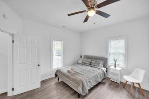 a white bedroom with a bed and a ceiling fan at Quiet Family Home - Downtown, Pet Friendly, 4 Beds in Raleigh