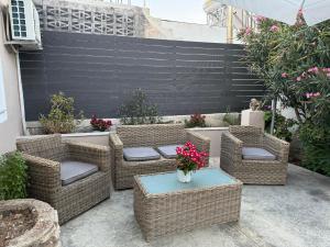 a patio with wicker chairs and a table with flowers at Sappir House in Pigadhákia