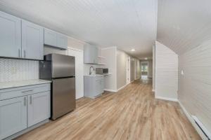 a large kitchen with white cabinets and a wooden floor at Perfect Private Unit in Passaic in Passaic