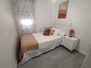 a small bedroom with a bed and a night stand at Apartamento en Toledo ideal para visitas a Puy du Fou in Toledo