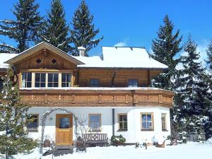 a large wooden house with snow on top of it at Landhaus Hinteregg Apartment in Schladming