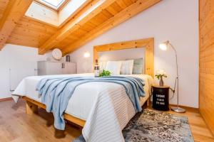 een slaapkamer met een groot bed in een kamer met houten plafonds bij Mezonet Lipno nad Vltavou in Lipno nad Vltavou