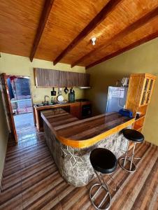 a kitchen with a large wooden bar with two stools at Xperience Hostel in San Pedro de Atacama