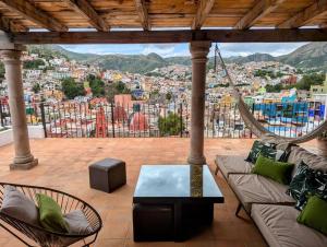 a patio with a hammock and a view of a city at Experience Guanajuato's Magic from Casa Mirador! in Guanajuato