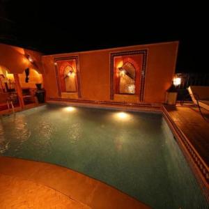 a swimming pool in a house at night at Dar Rihana Dadès in Aït Idaïr