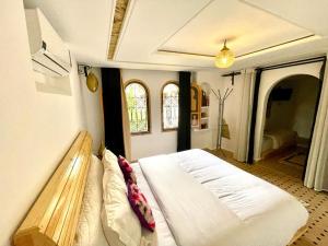 a bedroom with a bed with a bench in it at Dar Rihana Dadès in Aït Idaïr